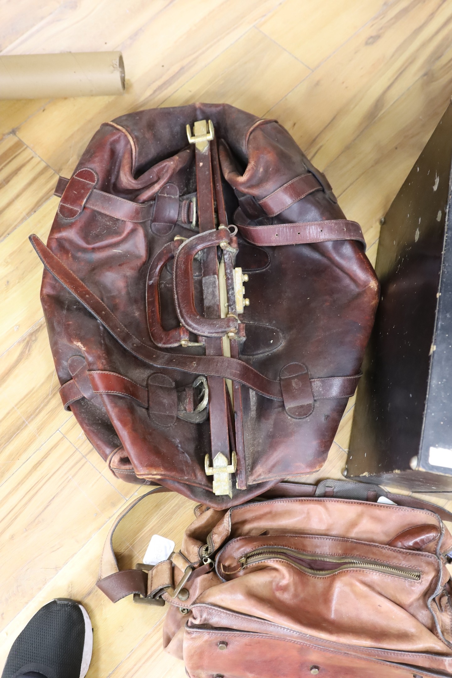 A large brown leather Gladstone bag, a Bally Italian brown leather satchel bag and a compatmental suitcase